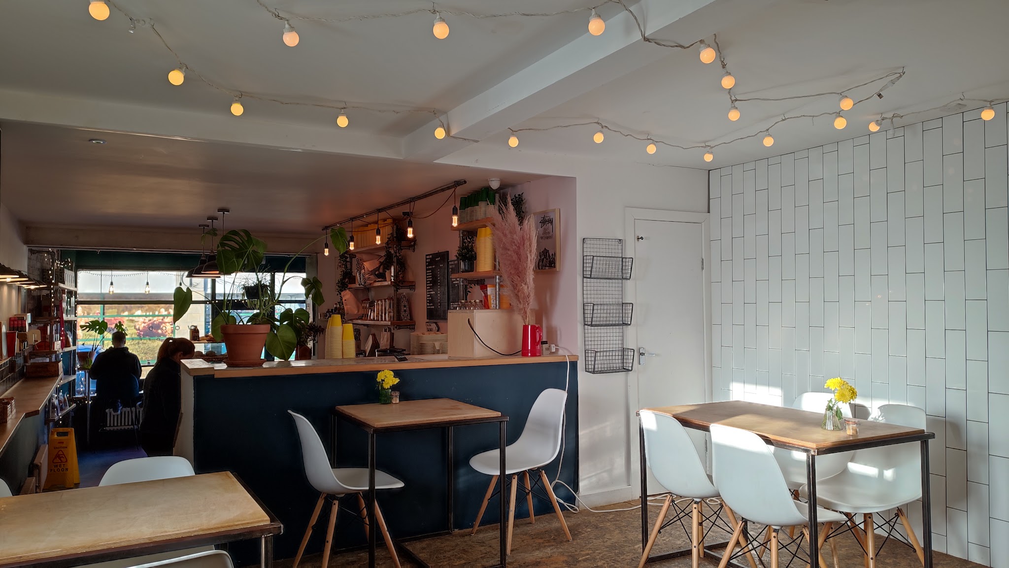 Woodlawn's cosy seating area with timber tables, white chairs and warm lights